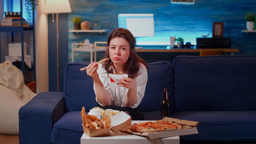 Portrait of woman using phone while sitting on table