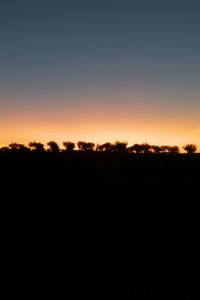 Silhouette landscape against clear sky during sunset