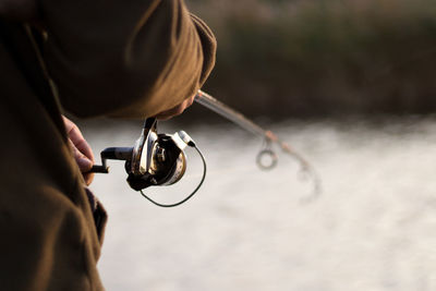 Close-up of man fishing in lake