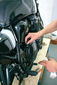 Close-up of man repairing motorcycle