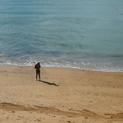 Rear view of man standing on beach