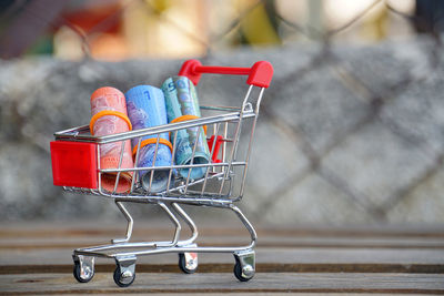 Close-up of rolled paper currency in small shopping cart on table