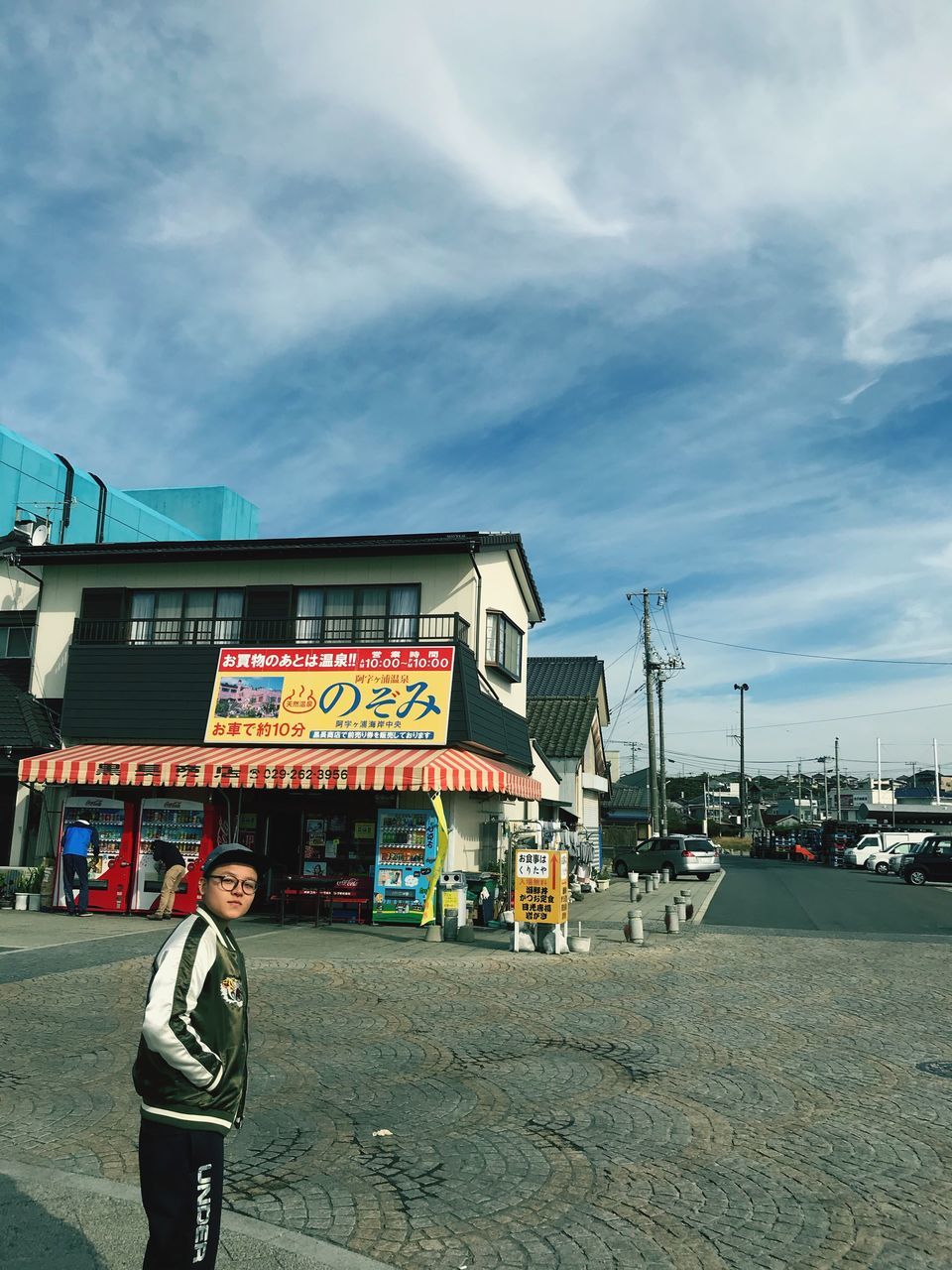 real people, architecture, building exterior, built structure, sky, outdoors, cloud - sky, one person, standing, day, full length, lifestyles, communication, men, occupation, women, city, people