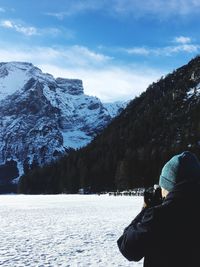 Rear view of person on snowcapped mountains against sky