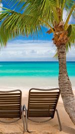 Chairs on beach against sky