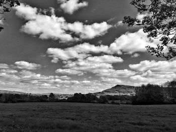 Scenic view of field against cloudy sky