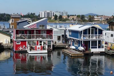 Boats moored on river by buildings in city