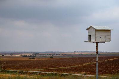 Lifeguard hut on field against sky