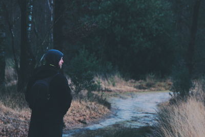 Rear view of man standing in forest