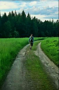 Full length of woman walking on grassy field