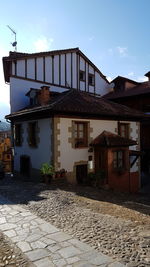 Houses by street in town against sky