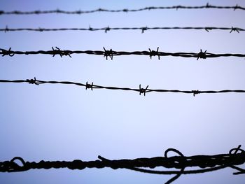 Low angle view of barbed wire against clear sky