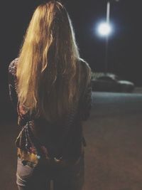 Rear view of woman at night