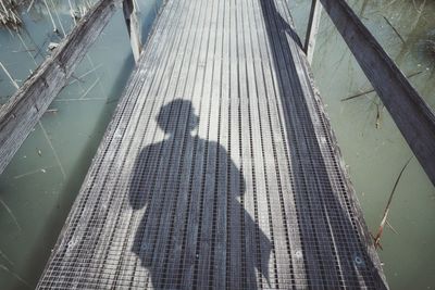 High angle view of shadow of people on bridge