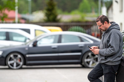 Side view of young man using mobile phone