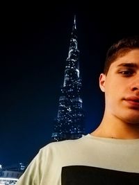 Portrait of young man standing against sky at night