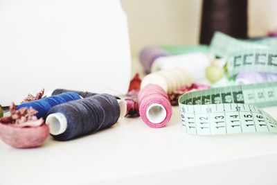 Close-up of spools and tape measure on table