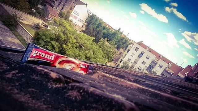 built structure, architecture, text, building exterior, sky, western script, tree, communication, low angle view, red, day, sign, transportation, railing, outdoors, information sign, railroad track, guidance, no people, road sign