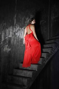 Midsection of woman standing against red wall