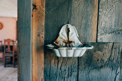 Close-up of old sink on wooden wall