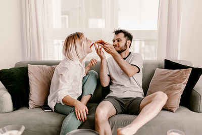 Friends sitting on sofa at home