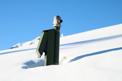 Low angle view of snow against clear blue sky