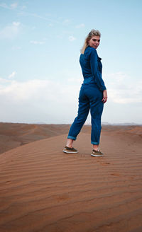 Full length of woman standing in desert