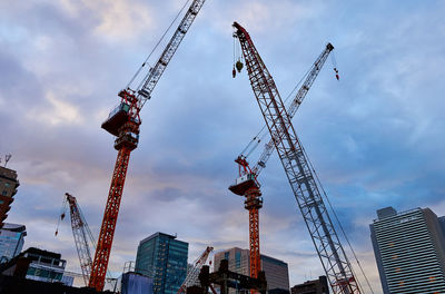 Low angle view of  construction cranes against sky in city