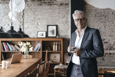 Senior businessman drinking coffee, smiling