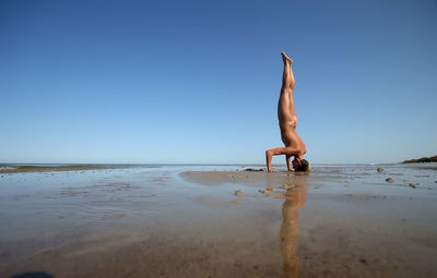 Full length of man on beach against clear sky