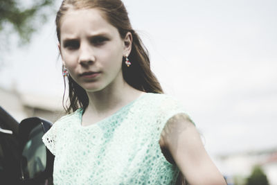 Close-up of young woman standing against sky