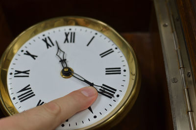 Close-up of hand holding clock
