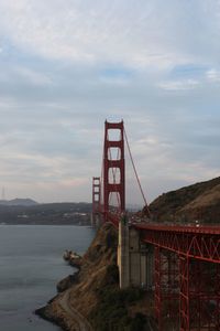 View of suspension bridge against cloudy sky