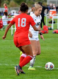 Women playing soccer on field