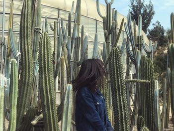 Rear view of woman standing against trees