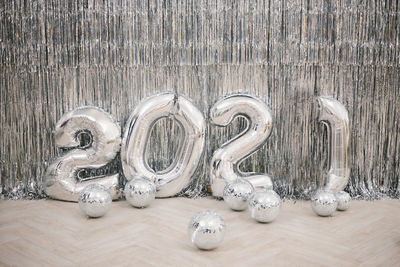 Numbers 2021 from silver colored balls against a silver wall. new year