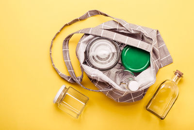 High angle view of containers on yellow background