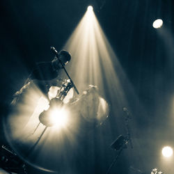 Low angle view of illuminated lighting equipment at night