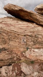 Text on rock against sky