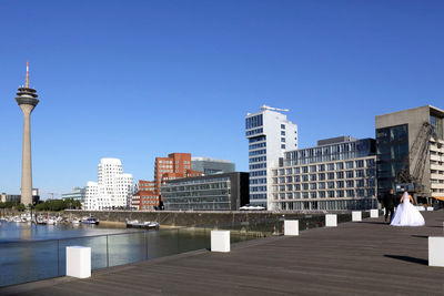 Modern buildings in city against blue sky