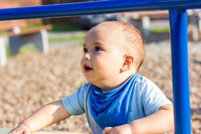Cute happy smiling baby boy playing at children playground outdoors