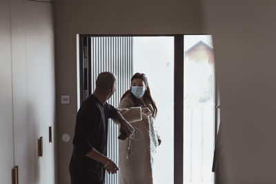 Friends standing against window