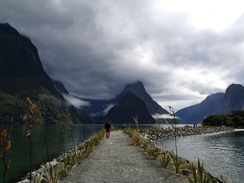 Rear view of people on riverbank against sky in a new zealand fjord