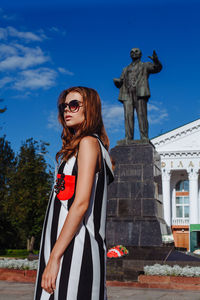 Fashionable young woman standing in city during sunny day