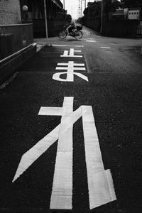 Close-up of arrow symbol on road in city