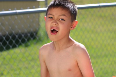 Portrait of shirtless boy playing outdoors