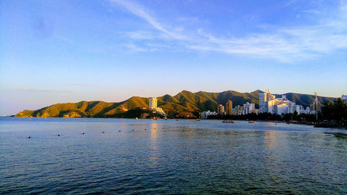 Scenic view of lake and mountains against blue sky