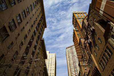 Low angle view of buildings against cloudy sky