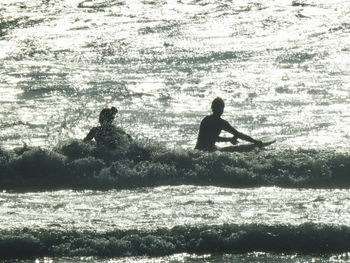 Silhouette people on sea shore