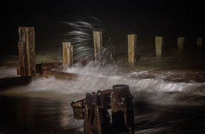 Water flowing through old wooden posts